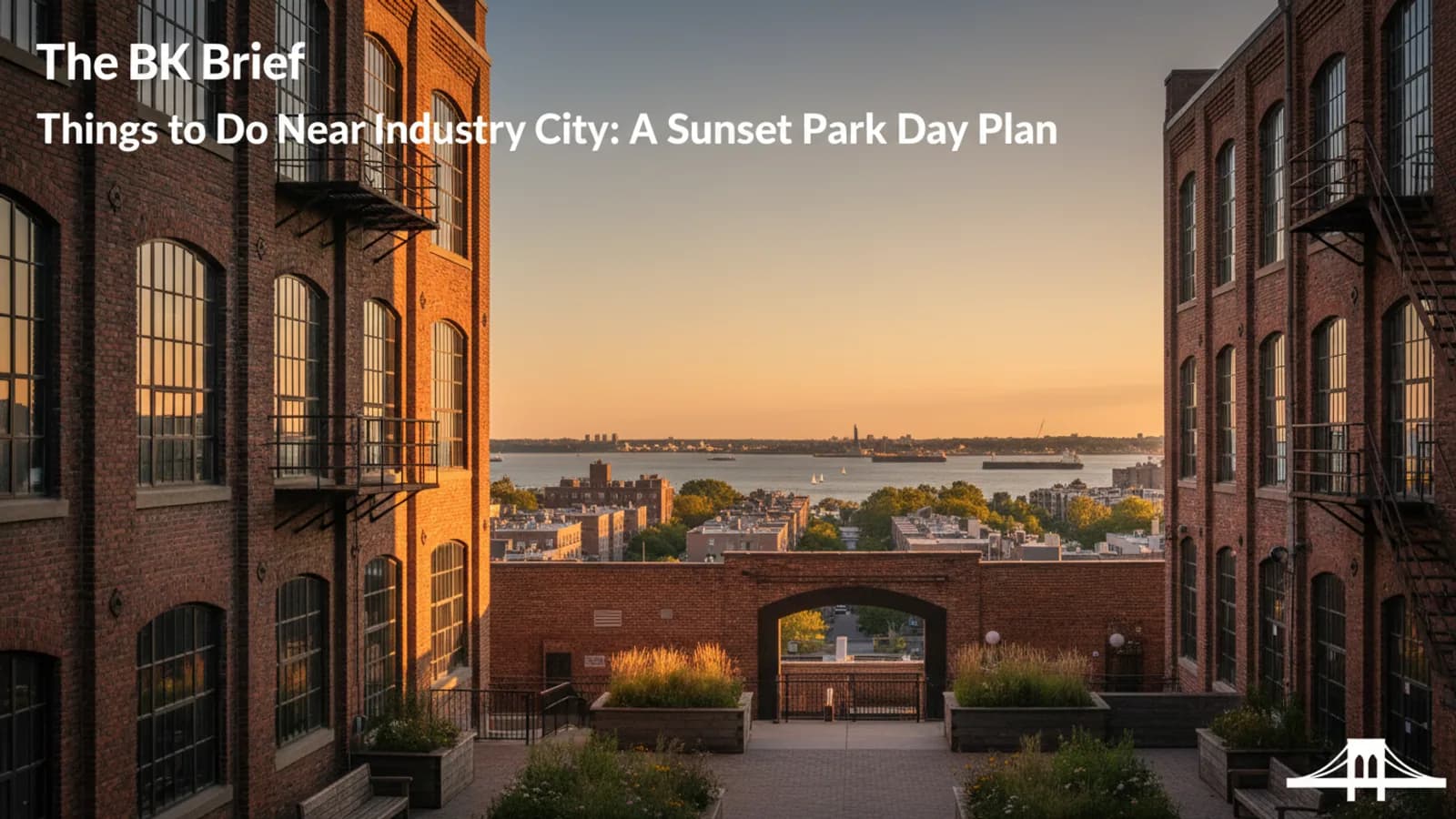 Industry City style brick industrial courtyard opening toward Sunset Park neighborhood and distant harbor view, editorial realism, no logos