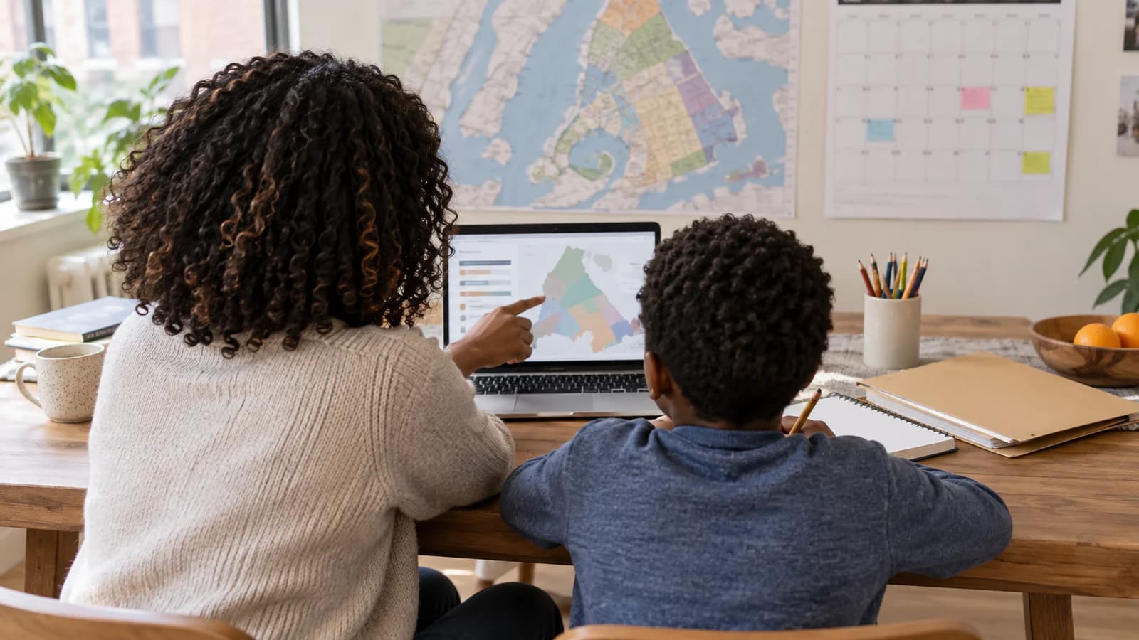 Caregiver and school-age child researching a generic Brooklyn school map together at a home workspace