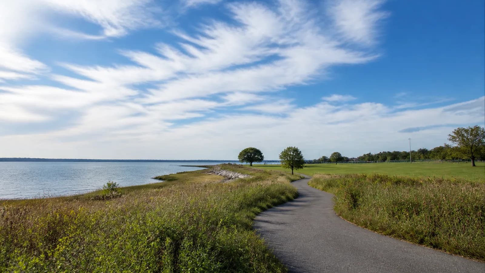 Waterfront path through native grasses and open fields at Calvert Vaux Park